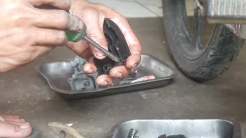 A mechanic is cleaning dirty motorcycle engine parts. Video stock 324942167