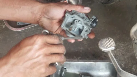 A mechanic is cleaning dirty motorcycle engine parts. Video stock 324942174