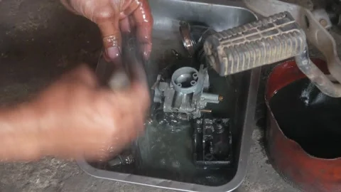 A mechanic is cleaning dirty motorcycle engine parts. Video stock 324942212