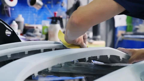 Mechanic cleans surface of car part using sandpaper Stock Footage 317634627