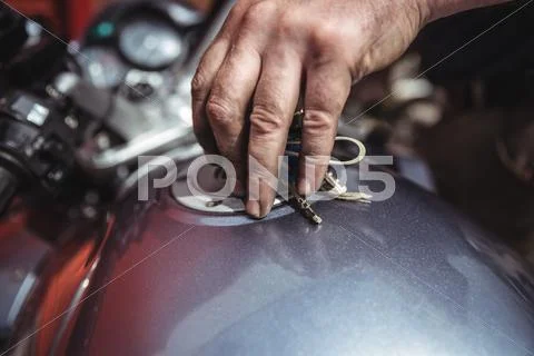Mechanic Closing A Fuel Tank Of Motor Bike