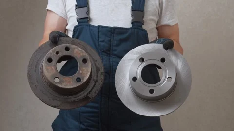 Mechanic comparing old rusted brake disc with new one Video stock 326147462