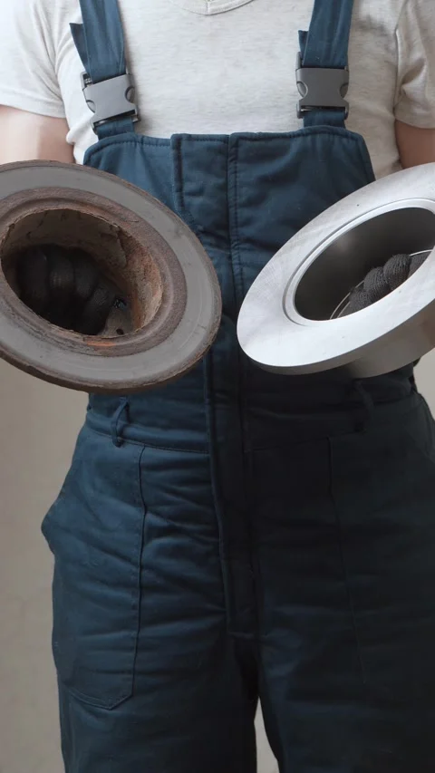 Mechanic comparing old rusty and new brake discs Vidéo 326142640