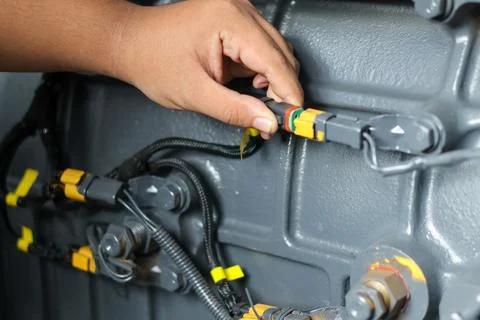 Mechanic connecting electrical wire harness connector. Stock Photos