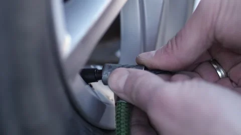 Mechanic connects thin pump hose before starting process of tyre inflating Stock-Footage 322127400
