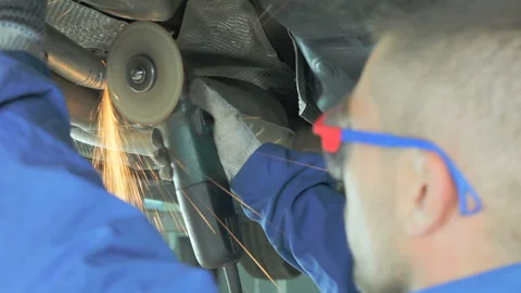 Mechanic cuts off the muffler in the car. Video stock 97205793