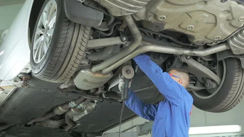 Mechanic cuts off the muffler in the car. Video stock 97415053