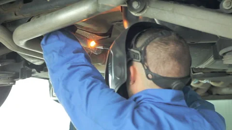 Mechanic cuts off the muffler in the car. Video stock 98155441