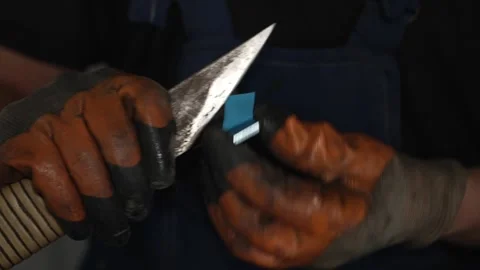 A mechanic cuts wheel balancing weights with a utility knife. Stock Footage 340978398