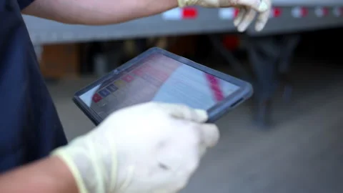 Mechanic diagnosing equipment with special software on the tablet in the truck Vídeos de archivo 315891612