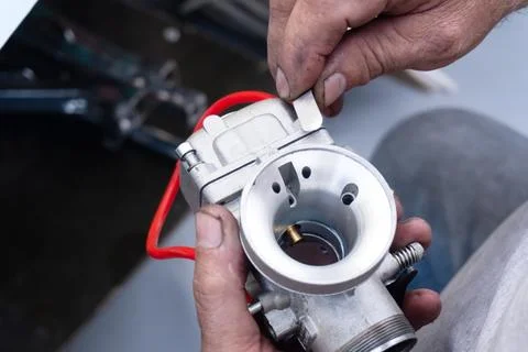 A mechanic disassembles a carburetor Stock Photos