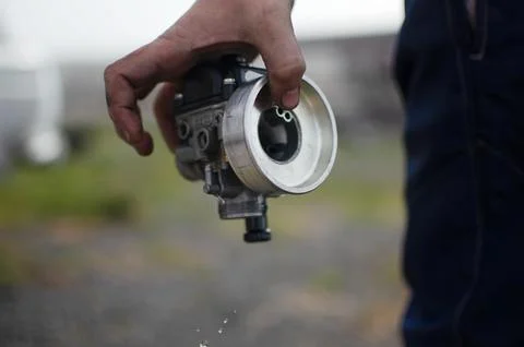 A mechanic disassembles a carburetor Stock Photos