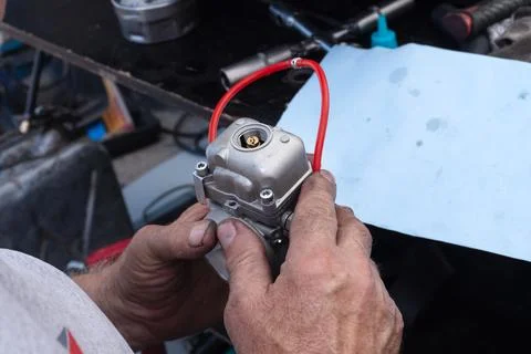 A mechanic disassembles a carburetor Stock Photos