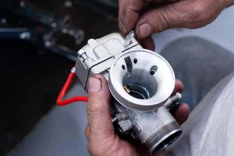 A mechanic disassembles a carburetor Stock Photos