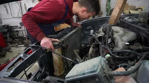 A mechanic disassembles an old dirty car 動画素材 221433748
