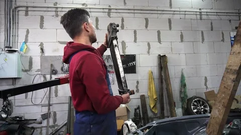 A mechanic disassembles an old dirty car Stockbeeldmateriaal 221433942
