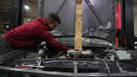 A mechanic disassembles an old dirty car Stockbeeldmateriaal 222888574
