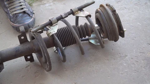 Mechanic disassembles shock absorber removed from car Stock Footage 118252986