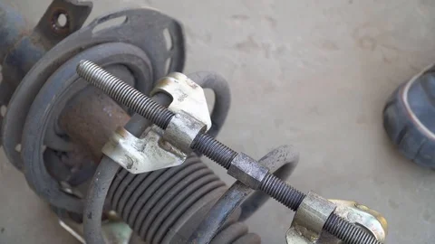 Mechanic disassembles shock absorber removed from car Stock Footage 118318477