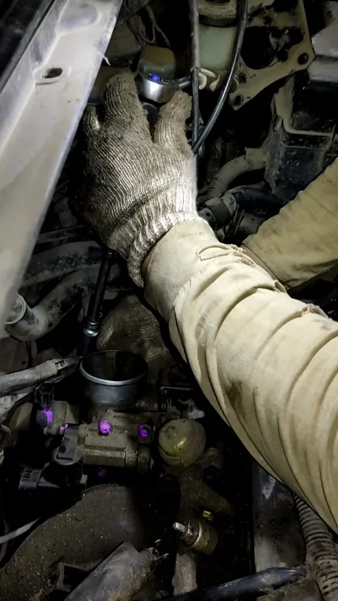 A mechanic disassembles various parts inside an open car engine. Stock Footage 338364855