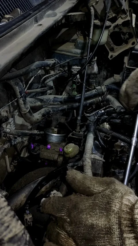 A mechanic disassembles various parts inside an open car engine. Stock Footage 338364865