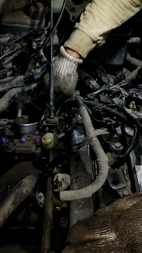 A mechanic disassembles various parts inside an open car engine. Stock Footage 338364891