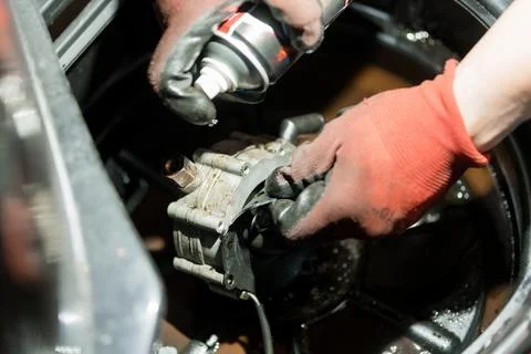 Mechanic Disassembling an Engine Component with Grease-Stained Gloves in a .. Foto stock