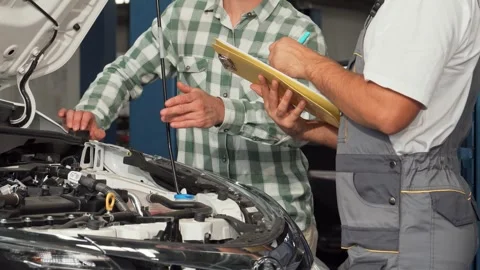 Mechanic discussing car issues while filling out paperwork Video stock 311512519