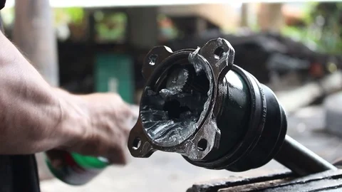 Mechanic doing maintenance applying grease to shaft Stock Footage 74016377