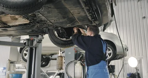 Mechanic Draining Old Brake Fluid From A System During The Service. Close Up Video stock 124957553