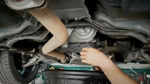 A mechanic drains car oil. Vídeos de archivo 101762163