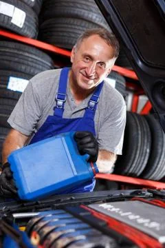 Mechanic engaged in replacement of engine oil 스톡 사진