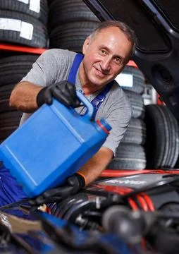 Mechanic engaged in replacement of engine oil 库存照片