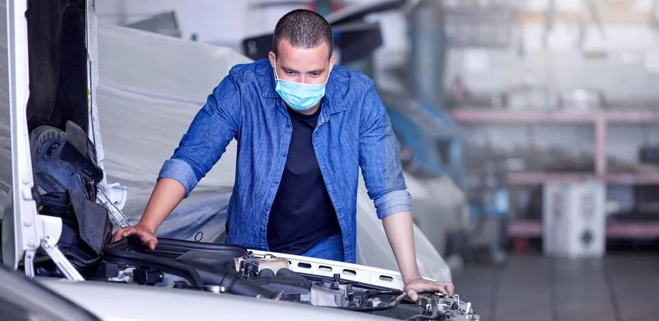 Mechanic, engine and car, man with face mask for covid safety at auto repair Stock Photos