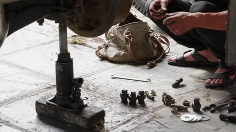 Mechanic examining disassembled engine parts on concrete floor 動画素材 342087532