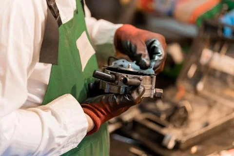 Mechanic Examining Engine Component with Precision in Workshop 写真素材