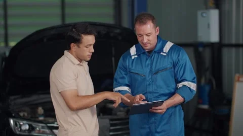 Mechanic explains vehicle issue to customer 스톡 동영상 347769640