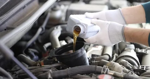 Mechanic fills car engine with engine oils Видео 249880403