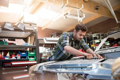 Mechanic fixing car engine in auto repair shop Stock Photos