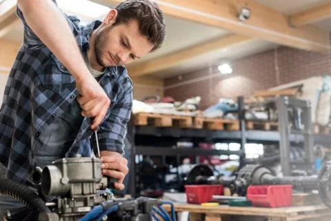 Mechanic fixing car engine in auto repair shop Stock Photos