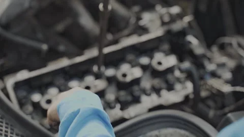 A mechanic is fixing a car engine in a workshop, using tools for professional 動画素材 283640074