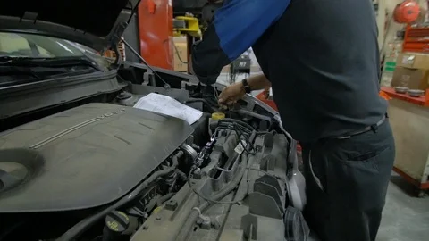 Mechanic Fixing &amp; Replacing Wire Harness Under Hood of Car Stock Footage 125352292