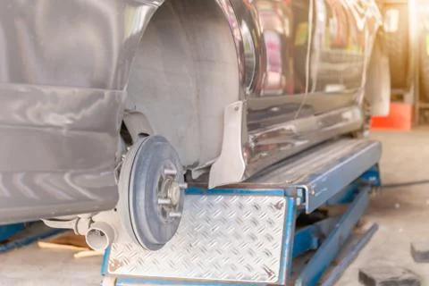Mechanic fixing the wheel alignment device onto a car wheel of new tire 写真素材