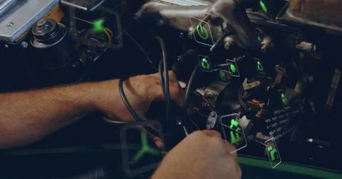 Mechanic forearms manipulating spark plug wires in garage bay, with neon green 写真素材