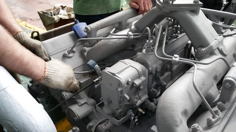 Mechanic Gathers the Motor for a Tractor or Truck in a Manufacturing Plant Stock Footage