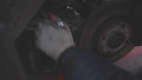 Mechanic gloved hand using wrench to unscrew wheel hub Stock Footage 280514873