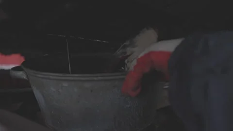 Mechanic in gloves draining used engine automobile oil into iron bucket in Stock Footage 275186956