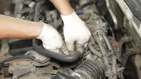 A mechanic in gloves fixing connections inside open car engine. Vídeos de archivo 342262251