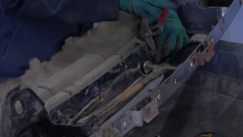A mechanic hammers in a rivet on a car bumper Stock Footage 77555752