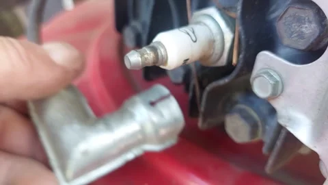Mechanic hand connecting a spark plug wire cap on a lawn mower engine. Stock Footage 335834113